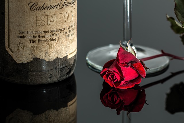 fľaša vína pri ruži